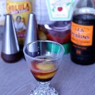 Prairie oyster drink with Lea & Perkins bottle and Cholula in background
