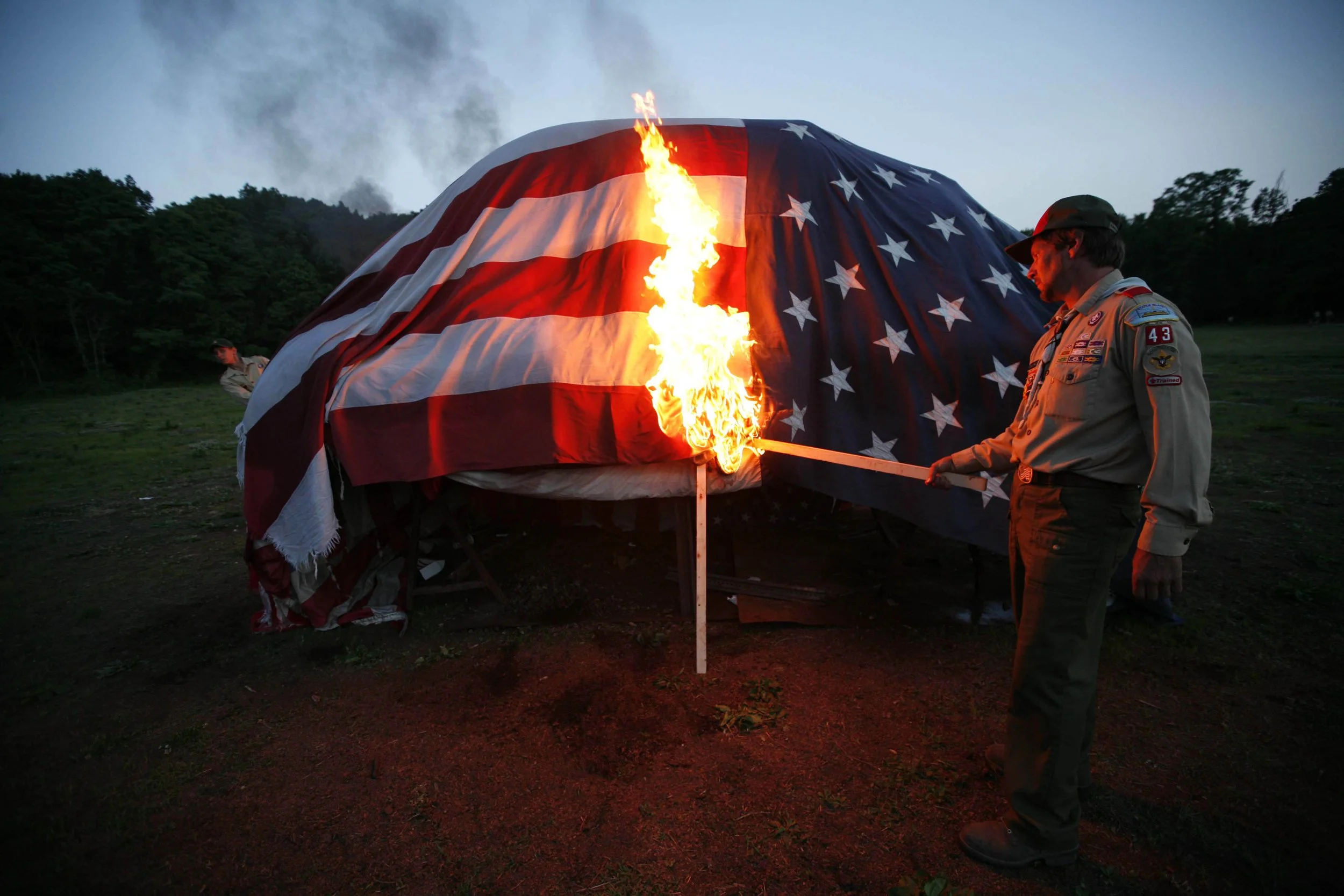  Scoutmaster Gil Schweiger ignites a pyre of worn American flags ceremonially retireing them Friday, June, 13, 2008 at Pouch Boy Scout Camp in Staten Island, N.Y.  