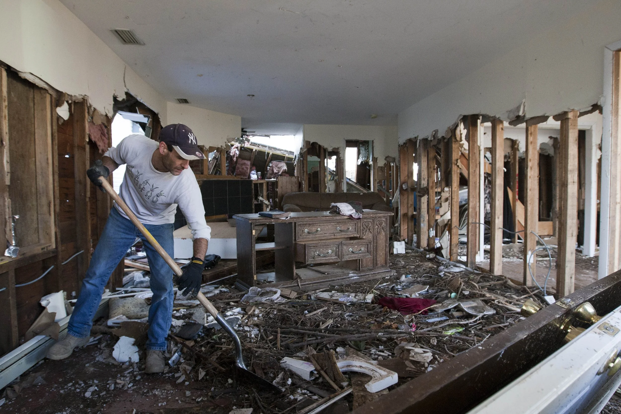  Dennis Murphy, of Seattle, shovels debris out of his uncle, Dominick Traina's, home in the New Dorp Beach neighborhood of Staten Island, Wednesday, Nov. 14, 2012.  