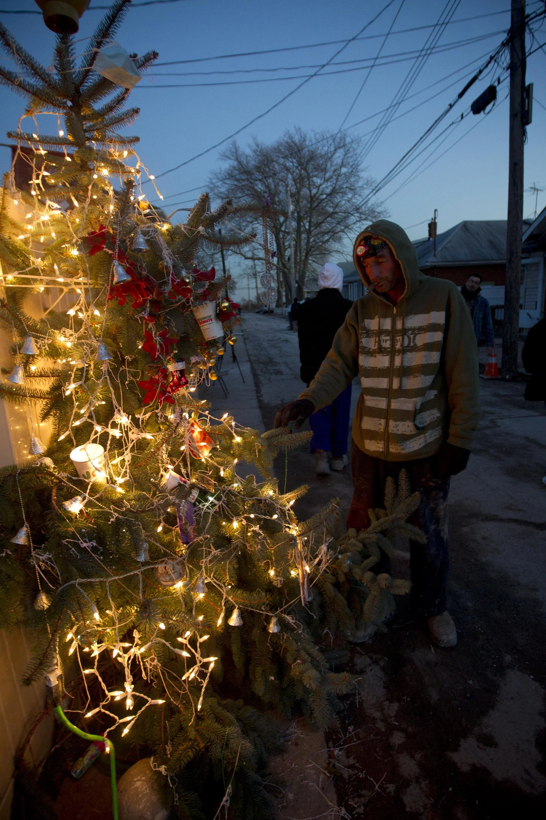  Joseph Ingenito poses with the remains of his prized blue spruce tree outside his home in the New Dorp Beach neighborhood of Staten Island, Wednesday, Nov. 14, 2012. Ingenito decorated the tree for Christmas with coffee cups and breathing masks.  