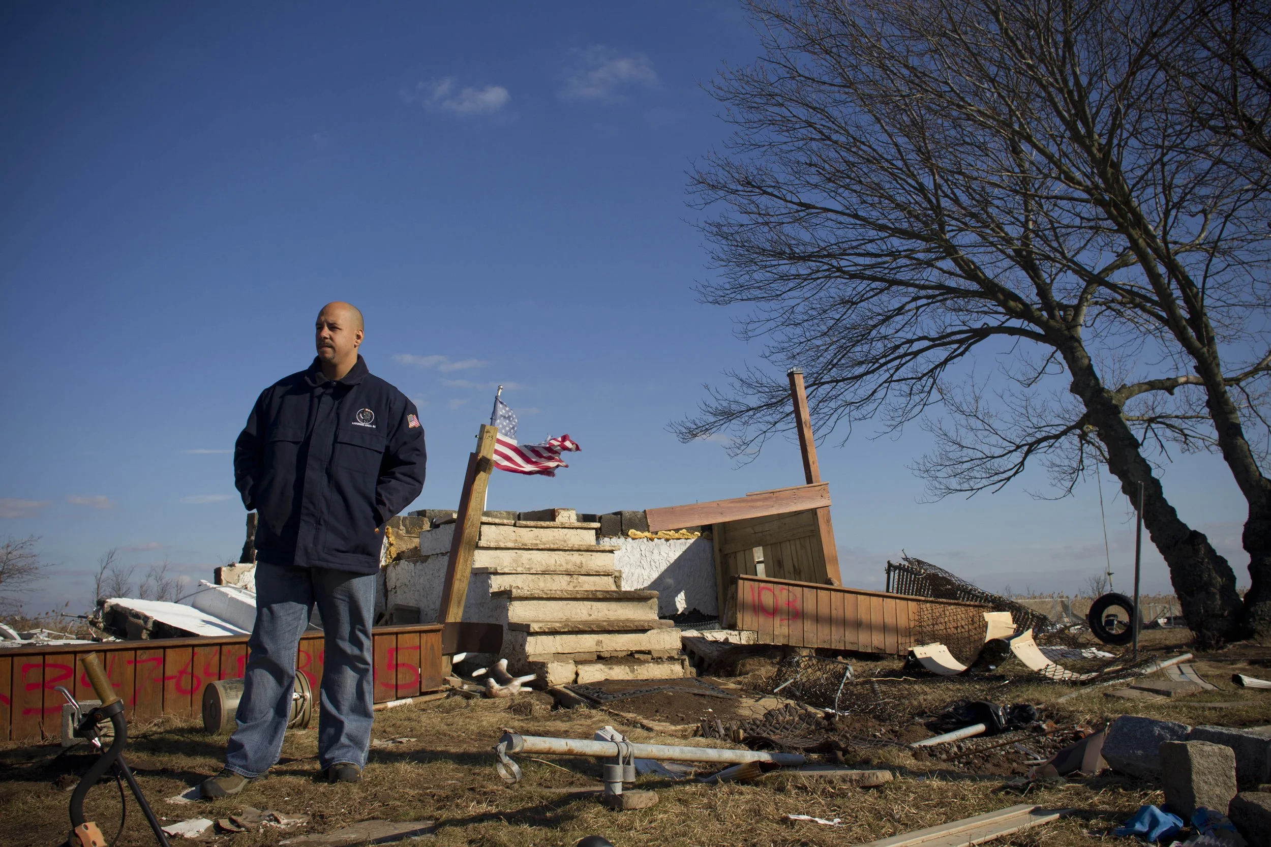  Sgt. Pedro Correa poses Wednesday, Nov. 28, 2012, with the remains of his home on Kissam Avenue in the Oakwood Beach neighborhood of Staten Island.  