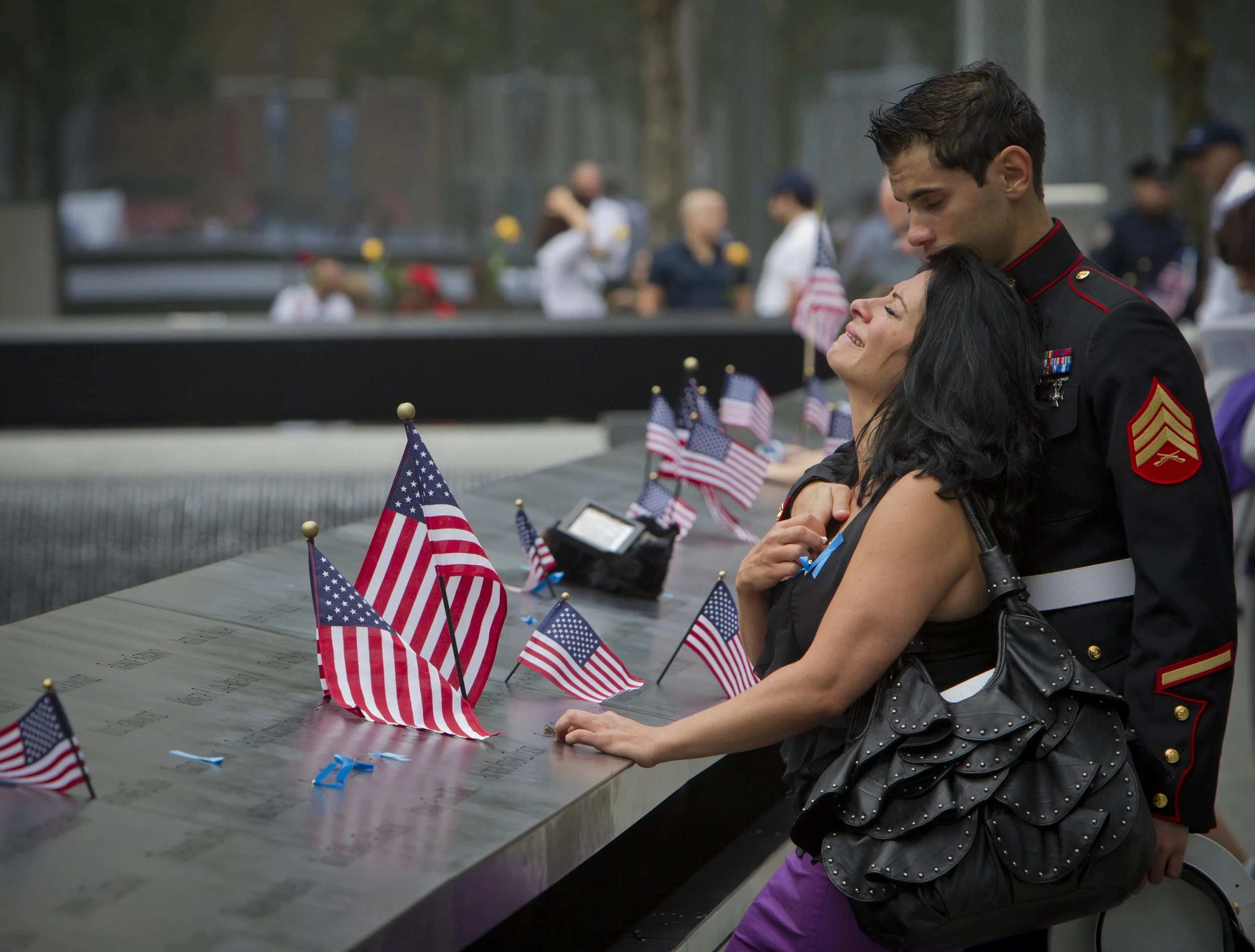  Nicky Figueredo, of Hoboken, is comforted by her boyfriend USMC Sgt. Andrew Kara as she mourns her best friend Sharon Christina Millan Sunday, Sept. 11, 2011, at the National 9/11 Memorial in New York. Millan, whose remains were never found, worked 