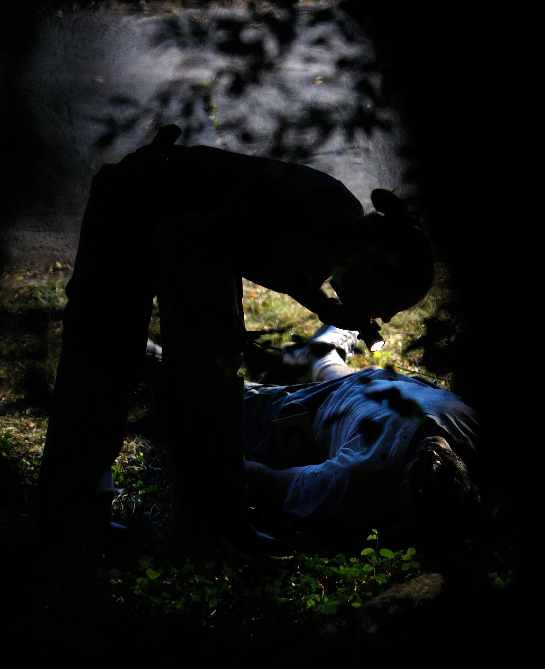  A New York Police crime scene investigator examines the body of Louis Buonacore, 44, who was found bludgeoned to death at Silver Lake Park Wednesday, July 16, 2008 in the Staten Island borough of New York. The homicide remains unsolved. 