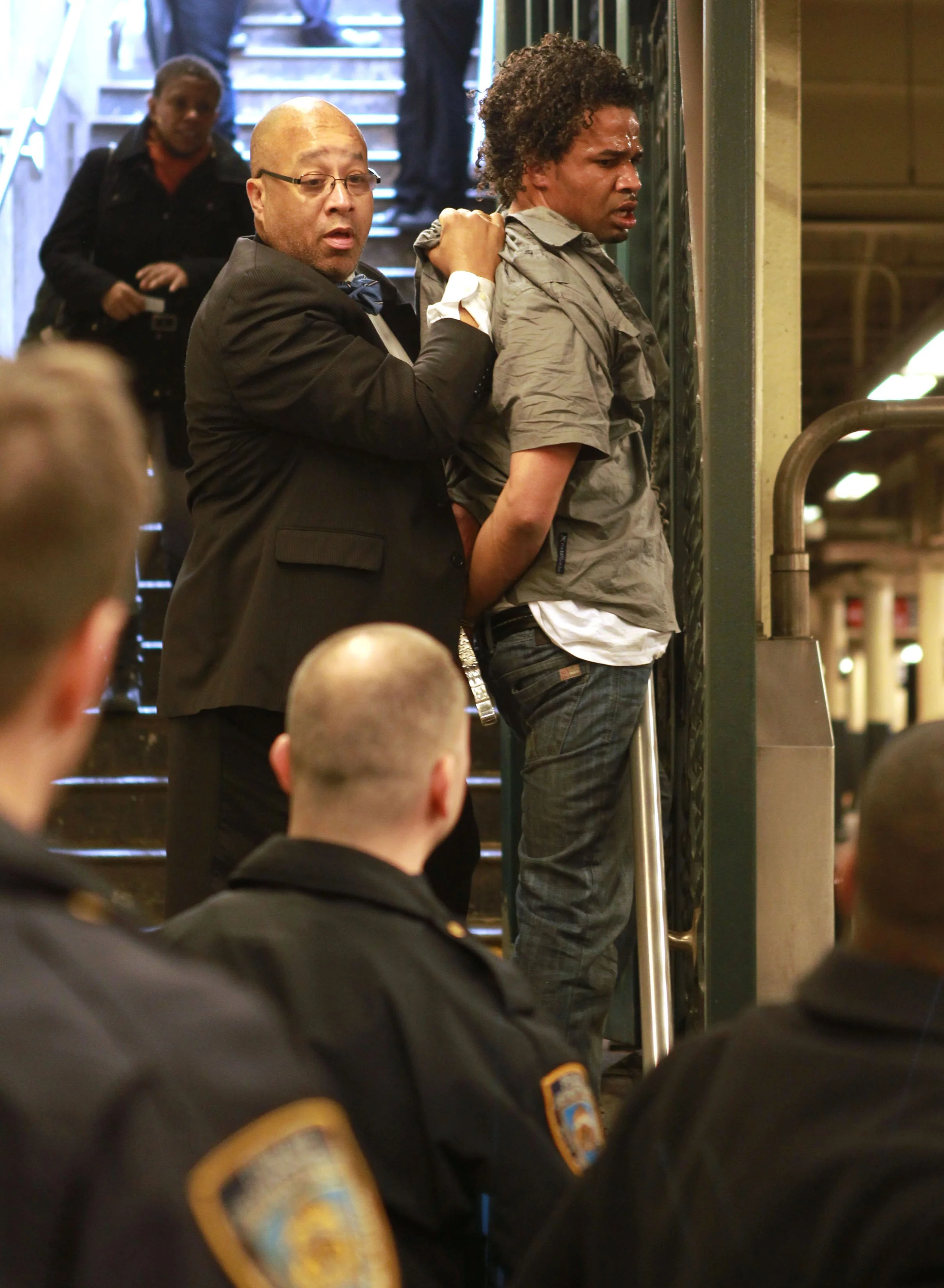  A well dressed Syms Department Store security guard detains a shoplifter as he tried to flee in the subway as New York Police Offices look on Thursday, March 24, 2011, at Wall Street and Broadway in New York. 