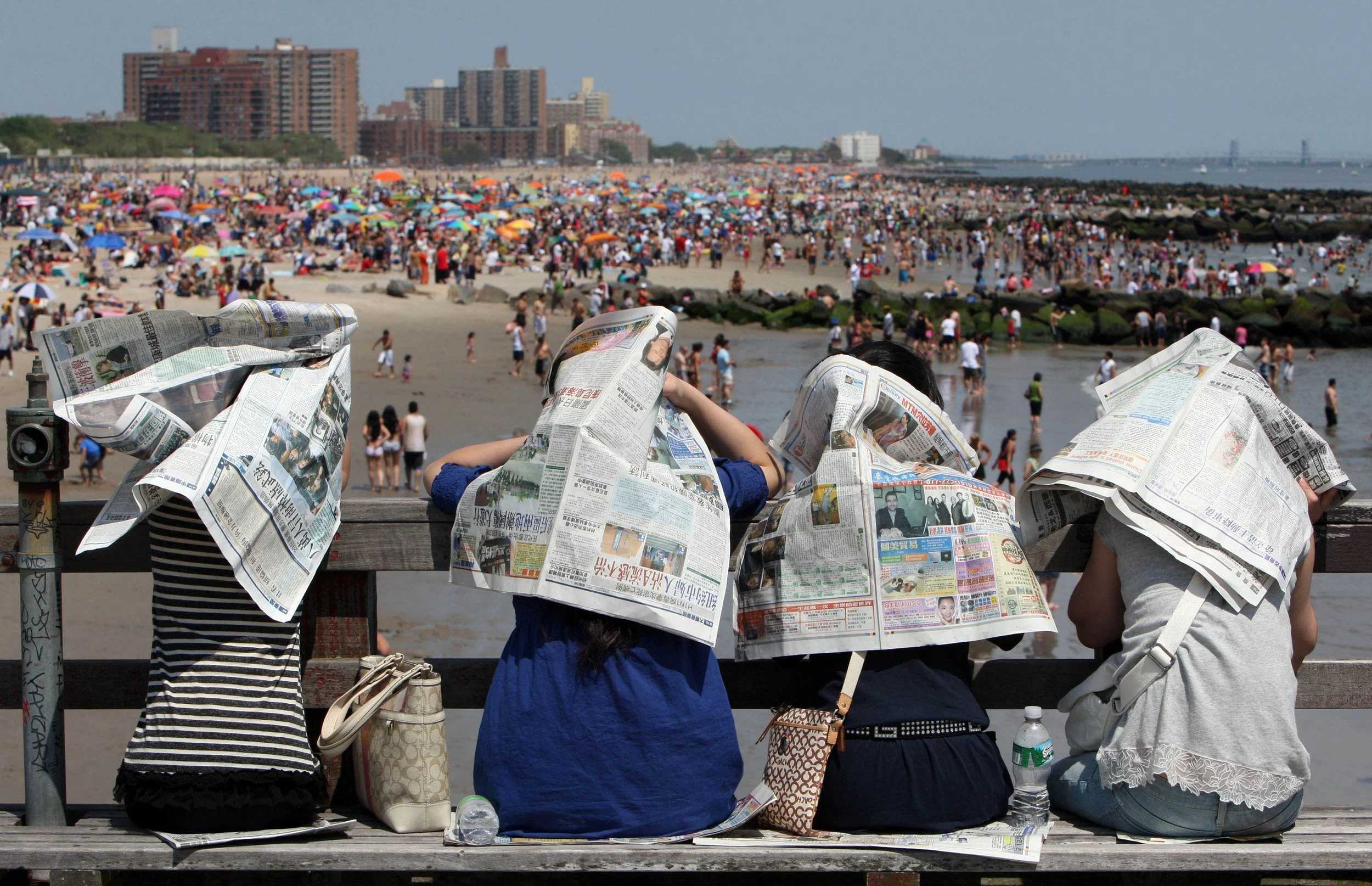  Ladies use newspaper to shield the sun on the Coney Island Beach fishing pier Monday, May 25, 2009 in the Brooklyn borough of New York. People flocked to the area beaches to soak up the 80 degree Memorial Day temperatures.  