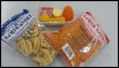 These are the different sweets and snacks shown to the children. The sweets include laddu (bottom left), mysore pak, jalebi (standing on right), palkova (white), and halwa (orange). The savoury snacks include muruku and boondi.