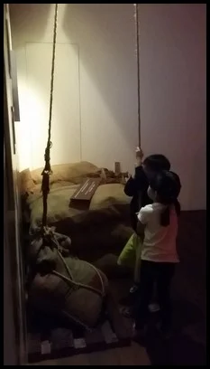 A group of men, also known as coolies, had to lift heavy sacks as their job. The children tried in pairs to lift a sack of rice with a pulley.