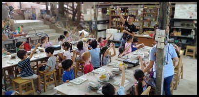  Mr Tan then explained to the children how to 'paste' the smaller shapes on the frames. A thin wooden stick with a sharp end was used to make small crosses on the back of the shapes to be pasted and on the part of the frame where the shapes are to be