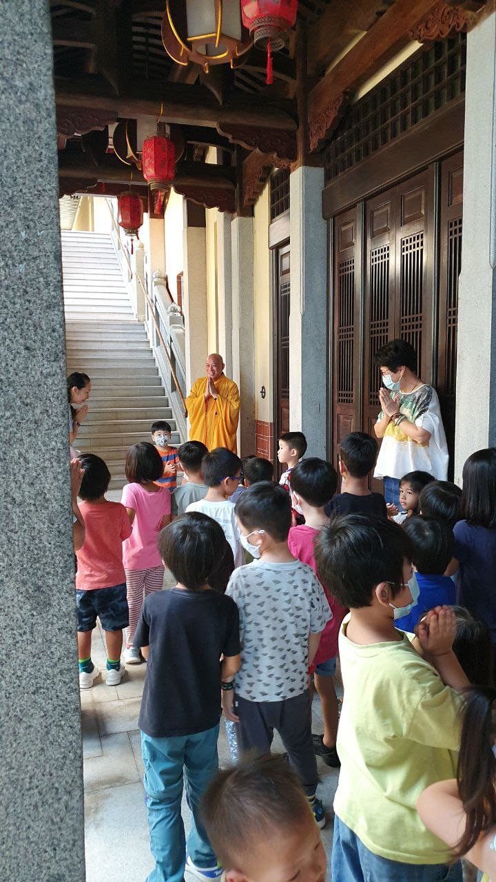  The children greeted a monk by putting two palms together near their chest, giving eye contact and smiling. 