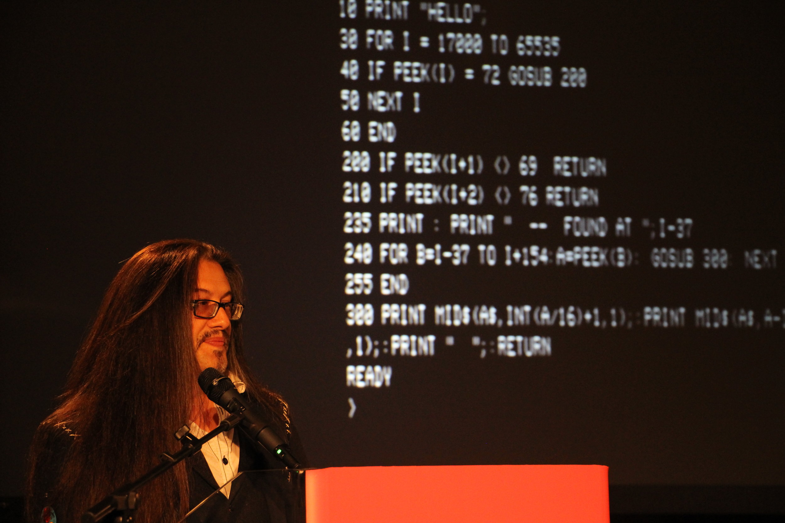 John Romero con del codice a caso sullo sfondo.jpg