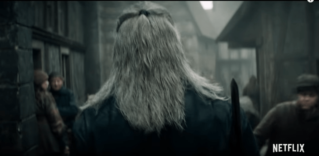 Il teaser inizia con il nostro massiccio Geralt (Henry Cavill) che attraversa una fatiscente città mentre è letteralmente schifato dallo sguardo dei villici. Questo frame è probabilmente tratto dalla puntata pilota della serie… che narrerà di Blaviken e di un certo fattaccio.