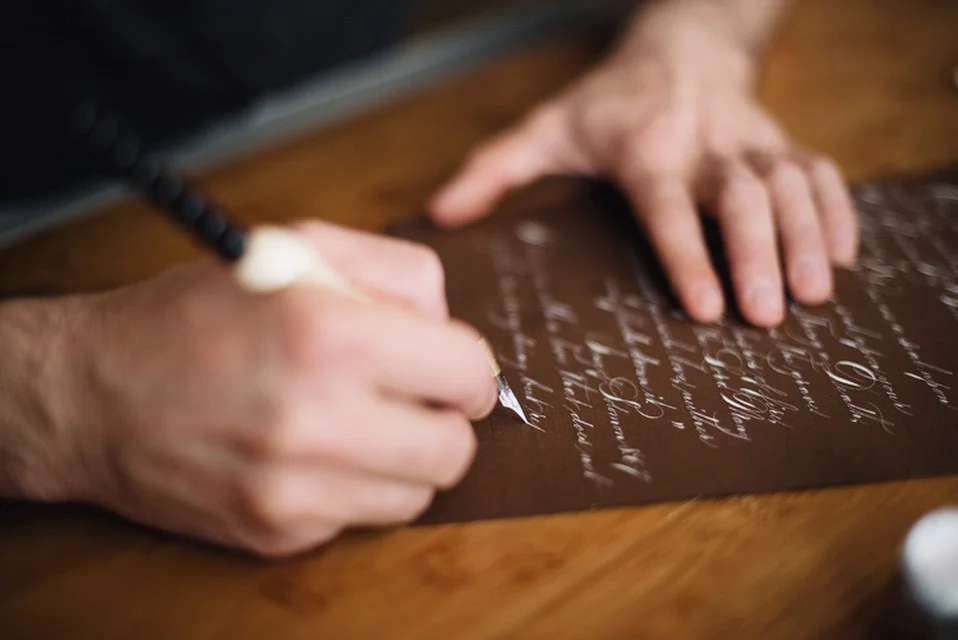 Hannah caught Jake writing this love letter in white ink on brown paper. It begins, "My Darling Fiance"...