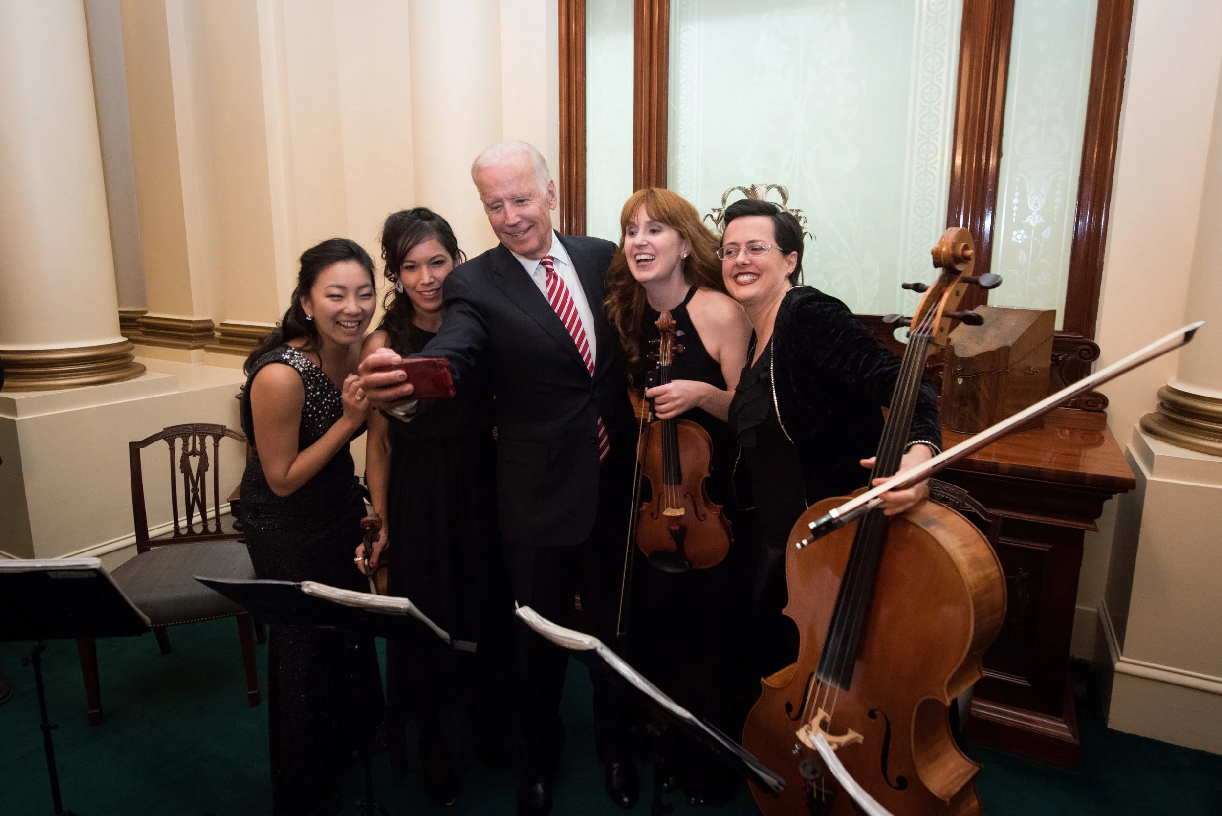 Former Vice President Joe Biden poses for a selfie with the string quartet