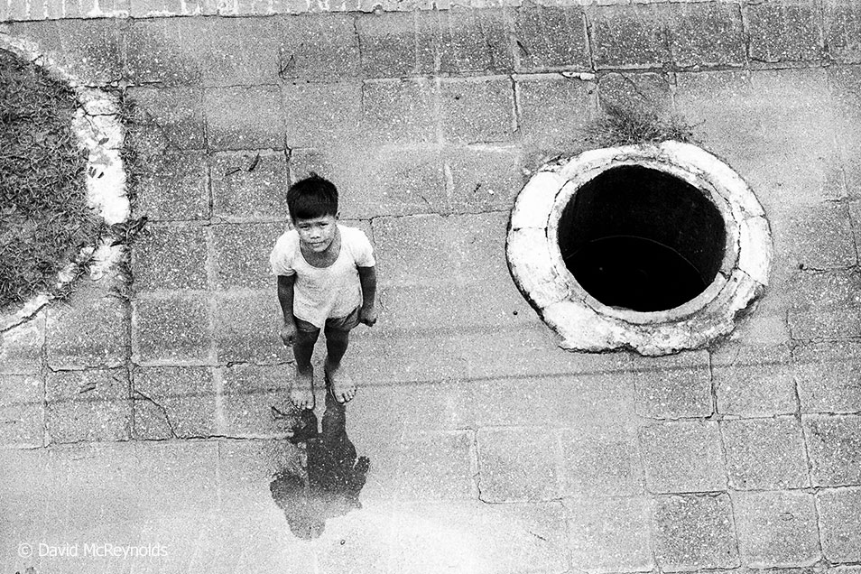  Child near sidewalk bomb shelter. Hanoi, 1971. 