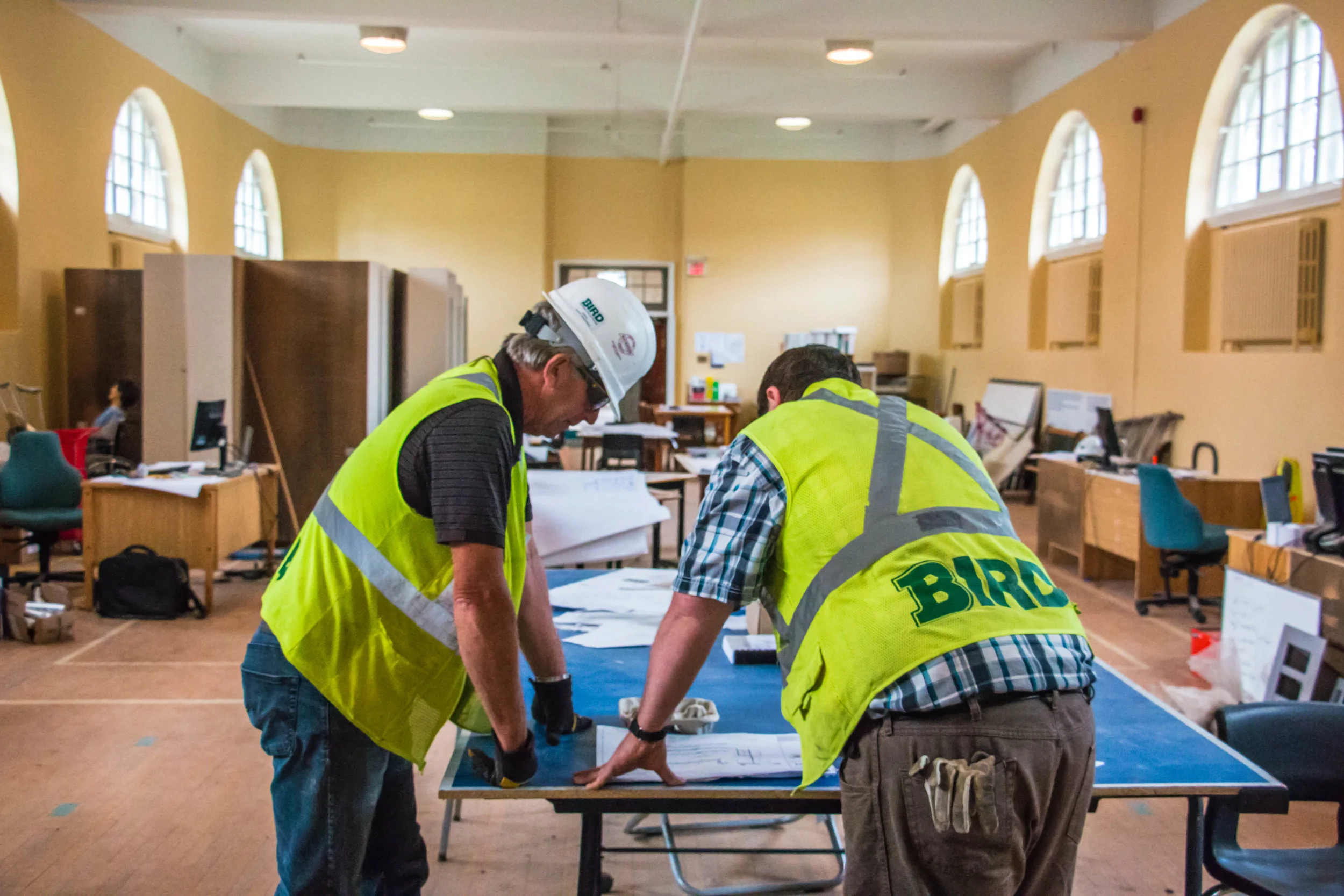  Two construction workers look over blueprints during the Mount St. Bernard renovations. 