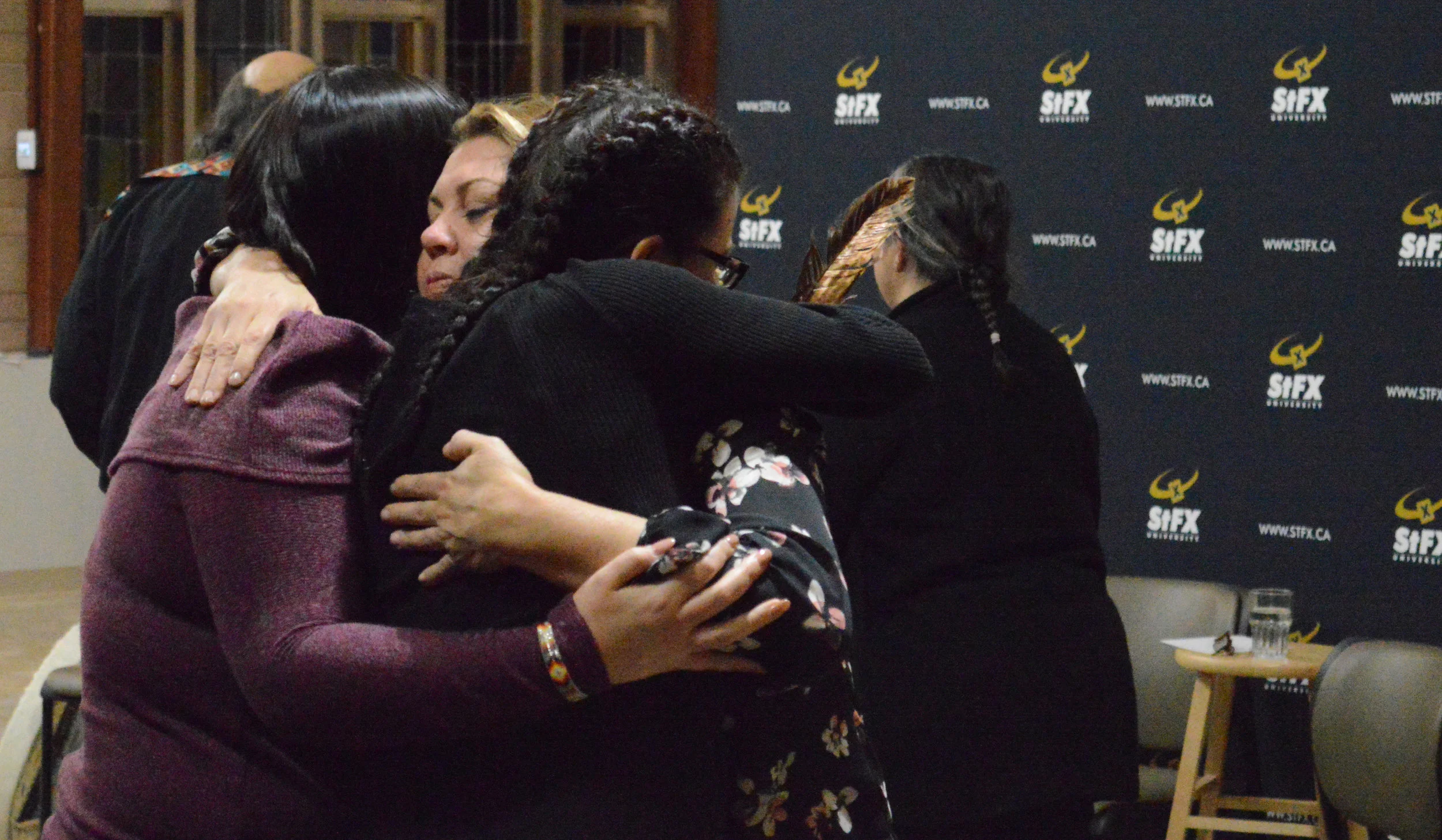  Cheryl Maloney, a panelist at the President's Colloquium on Social Justice for Reconciliation, hugs two StFX students after the discussion on Nov 3. 