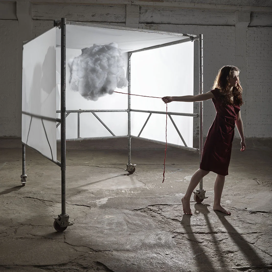 Tesseract woman standing outside of scaffold holding dream cloud