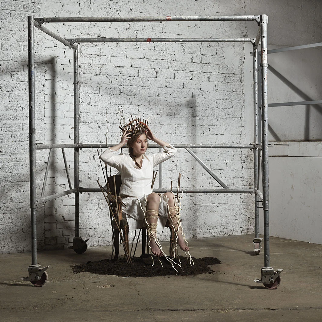 Tesseract woman rooted to earth wearing self-made crown