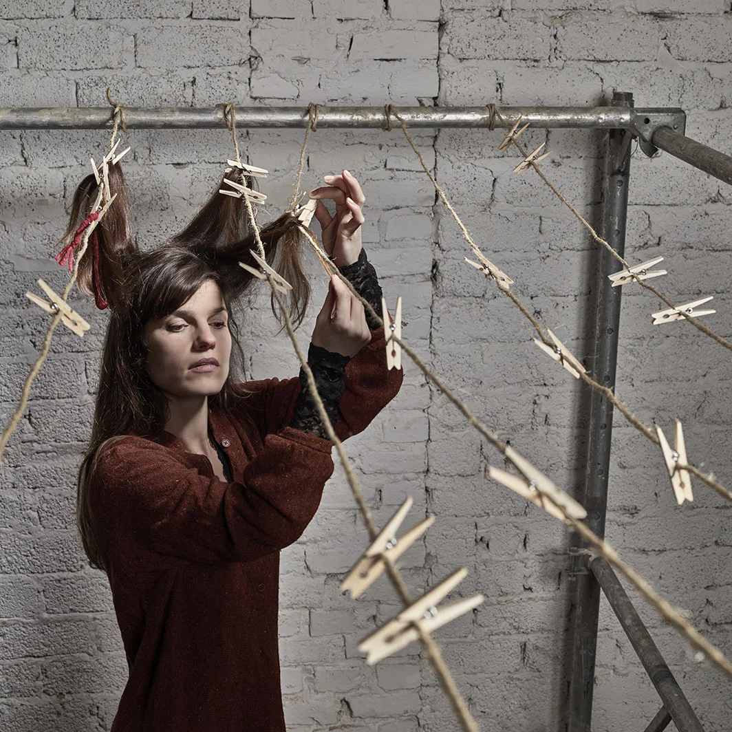 Tesseract woman tying her own hair to cloth line