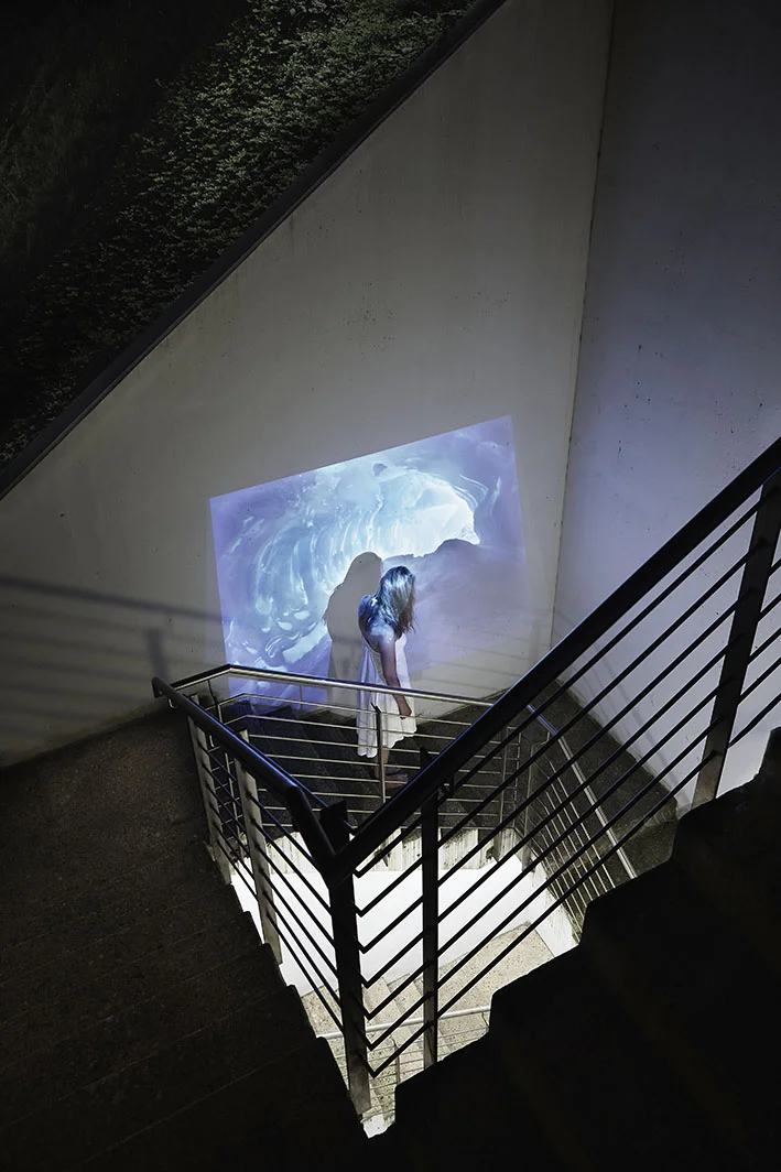 Projektion-Frau-steht-auf-Treppe-vor-Eishoehle