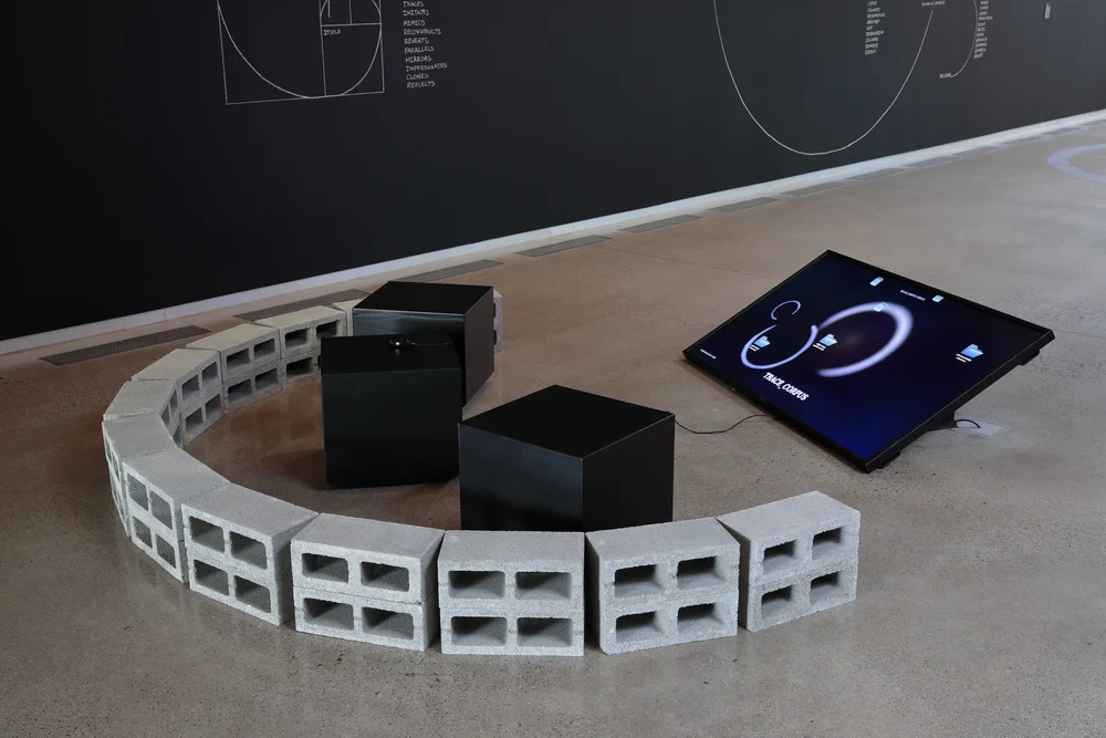 Nolan Oswald Dennis: trace xb, 2024. Concrete brick (Left) Nolan Oswald Dennis, Black Earth Corpus, 2024. Three monitors, three joysticks, local server. Dimensions variable (Right)