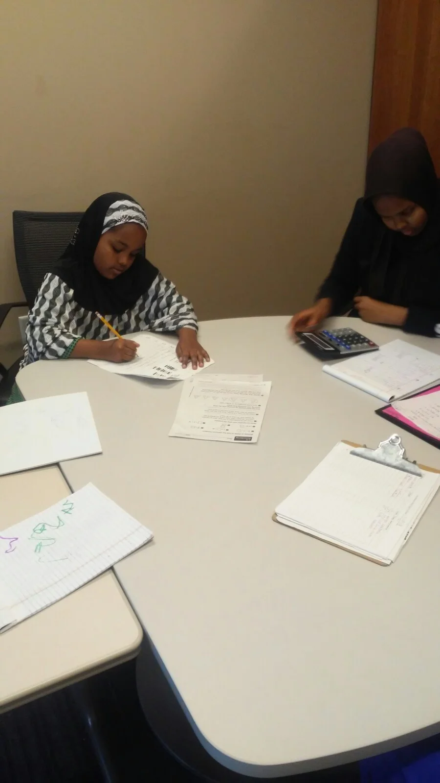 Riyana, left, works on homework, with tutor Rahma, right.