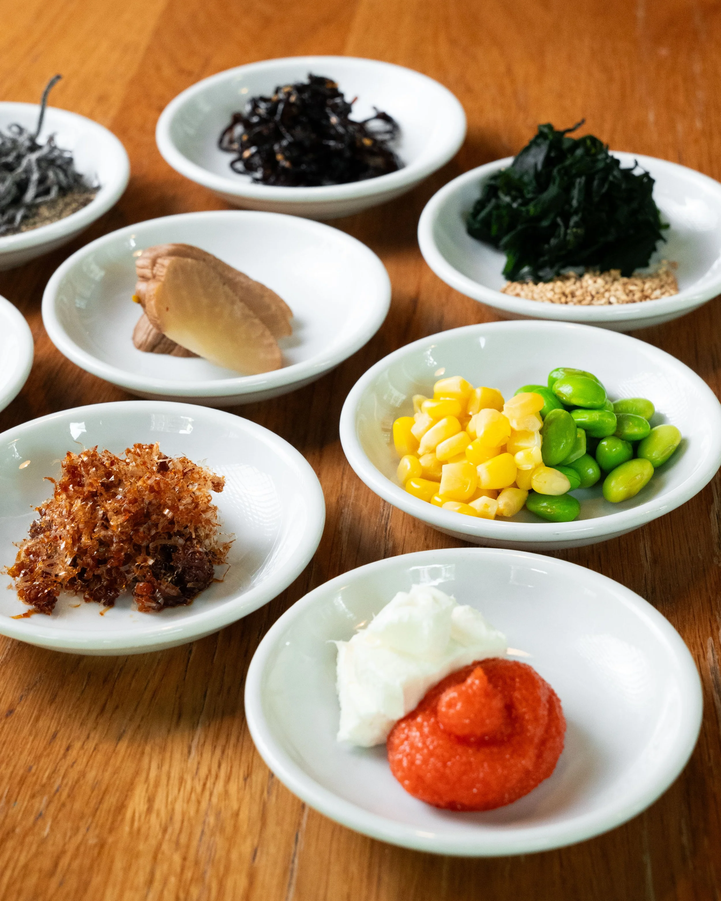 Assortment of onigiri fillings on small plates
