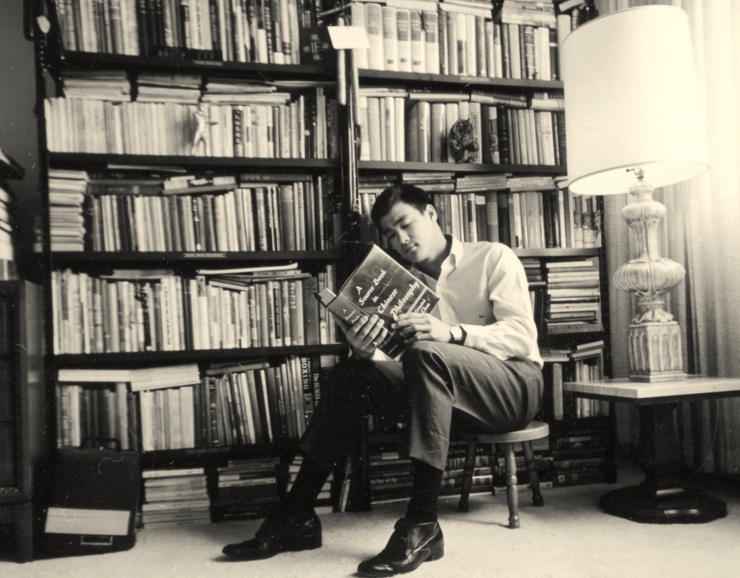 Bruce Lee while reading a book in a library