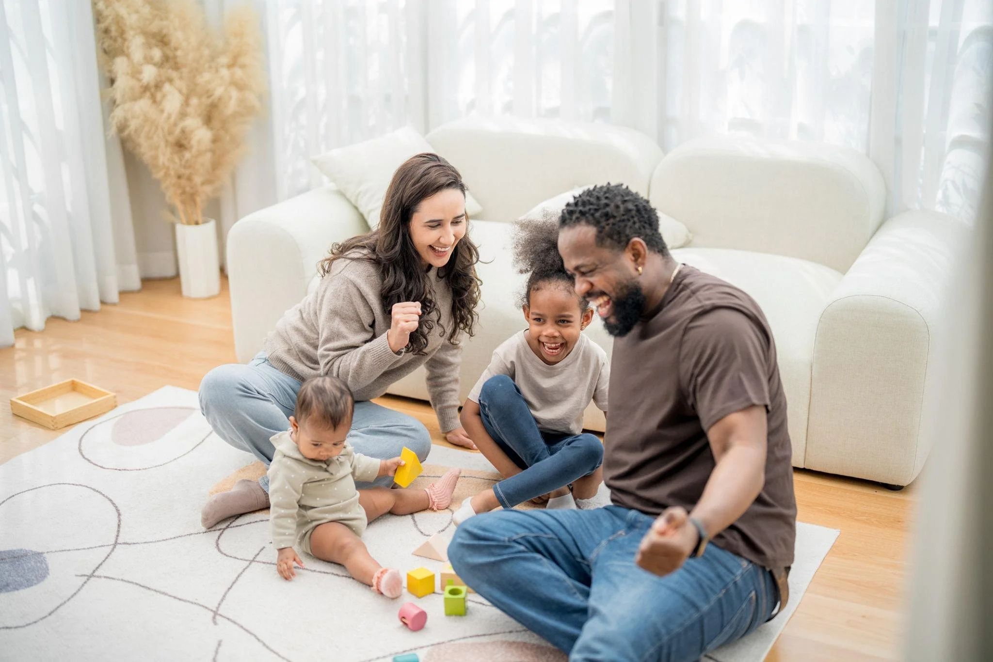 A warm, natural photograph of parents spending time with their young children at home. Place here to reinforce the personal importance of guardianship decisions.
