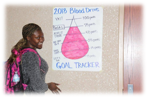 Issues Specialist, Abidemi Folorunso, filling in the goal chart for the number of pints collected