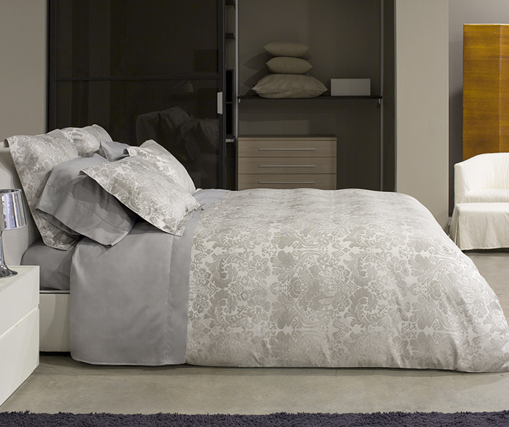 Oriente is a luxurious Italian jacquard with a soft silver and grey sateen finish. It has a traditional appeal with a modernized classic pattern the stands the test of time. by Signoria Firenze