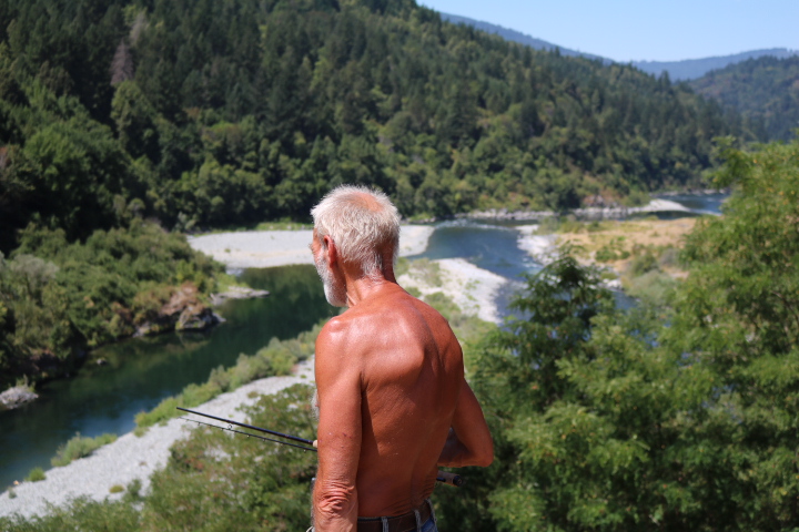 An old salmon fisherman searches for moving shadows above the confluence of the Trinity and Klamath Rivers 
