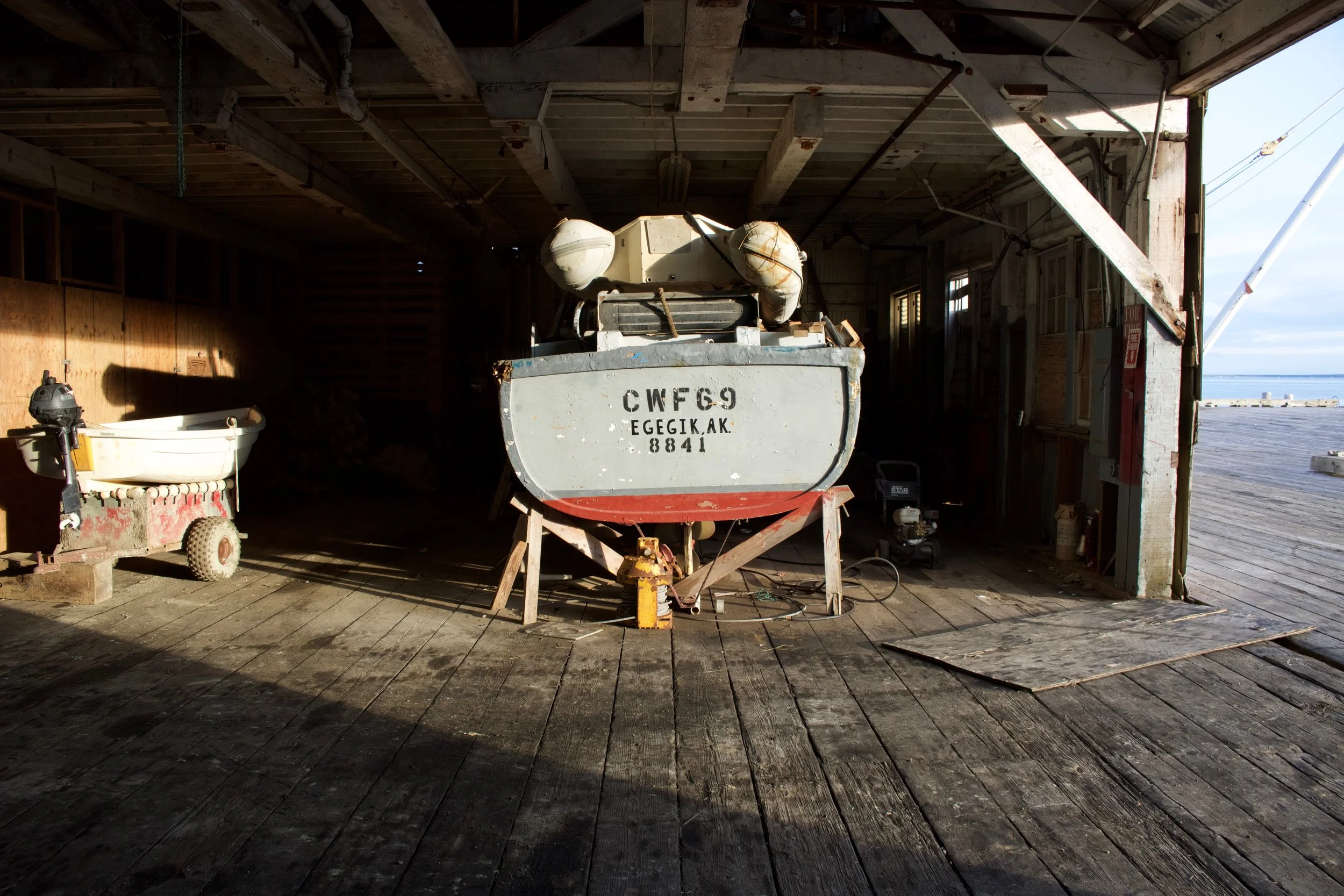 An old tender on stilts being stored inside the cannery building