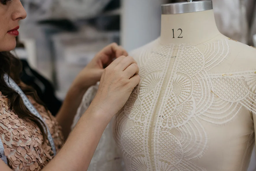 Refining lace placement on the mannequin in our studio