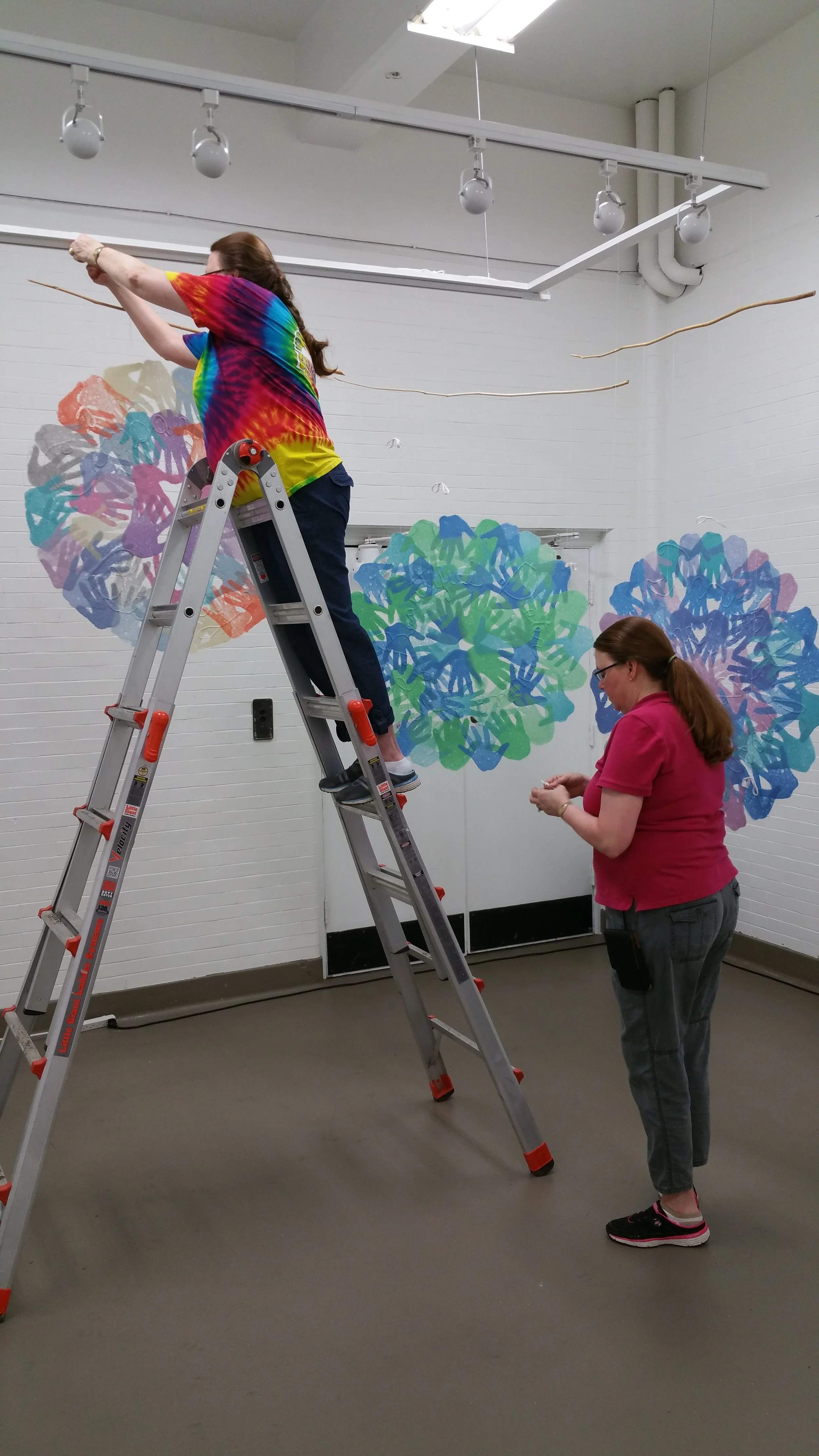 Veda and Meda Rives install three pages of their hand-made paper pieces, Inner Circle.
