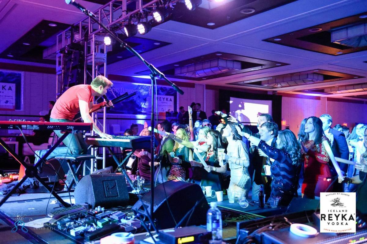David Higgens playing keyboard and singing on stage for the dancing portion of a dinner and dancing event