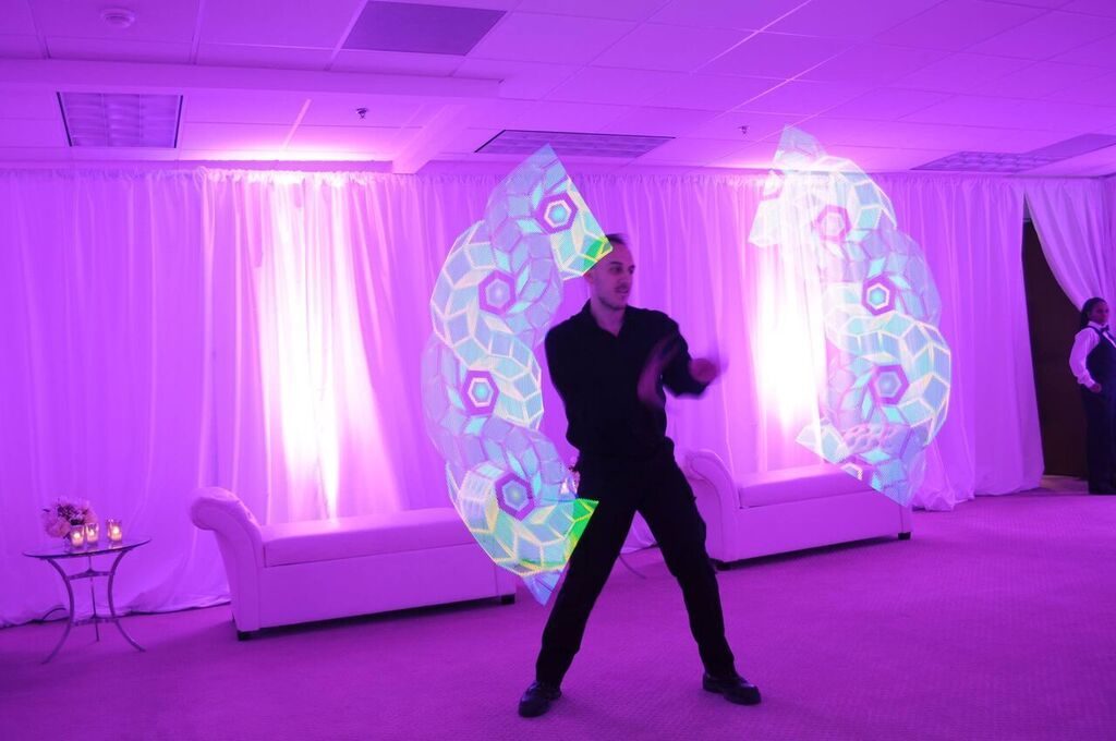 Performer spinning LED Poi creating a geometric design in the air