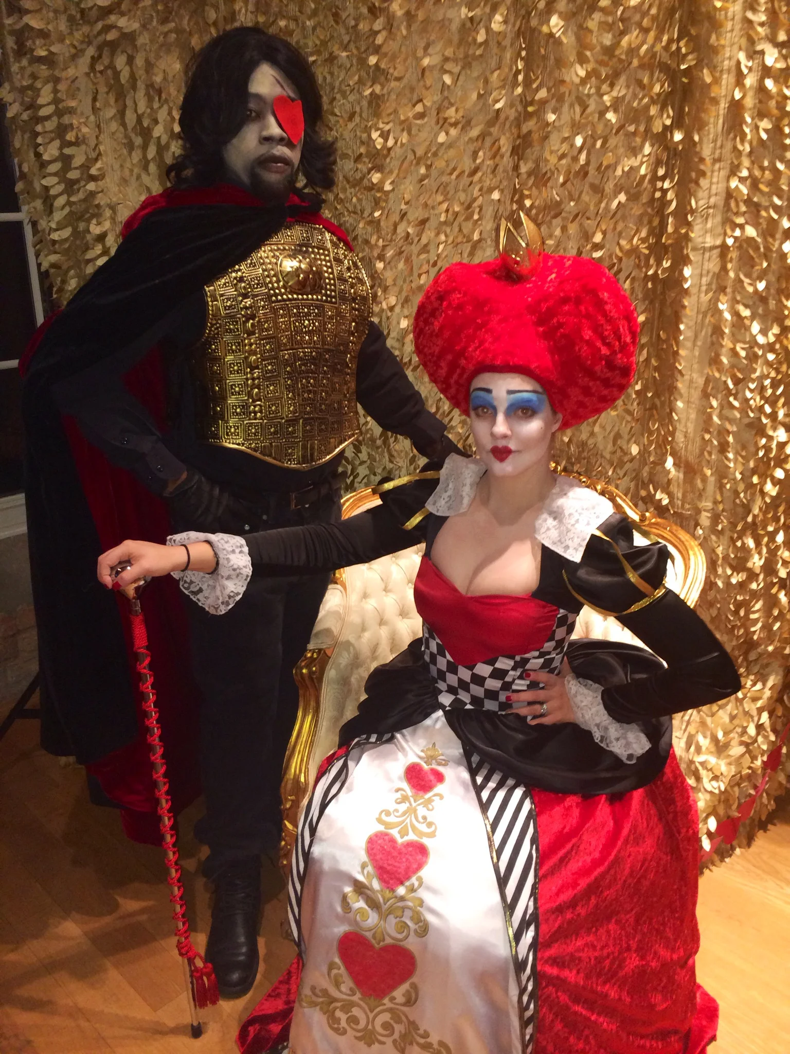 Two performers in Red Queen and guard inspired costumes for an Alice in Wonderland themed party