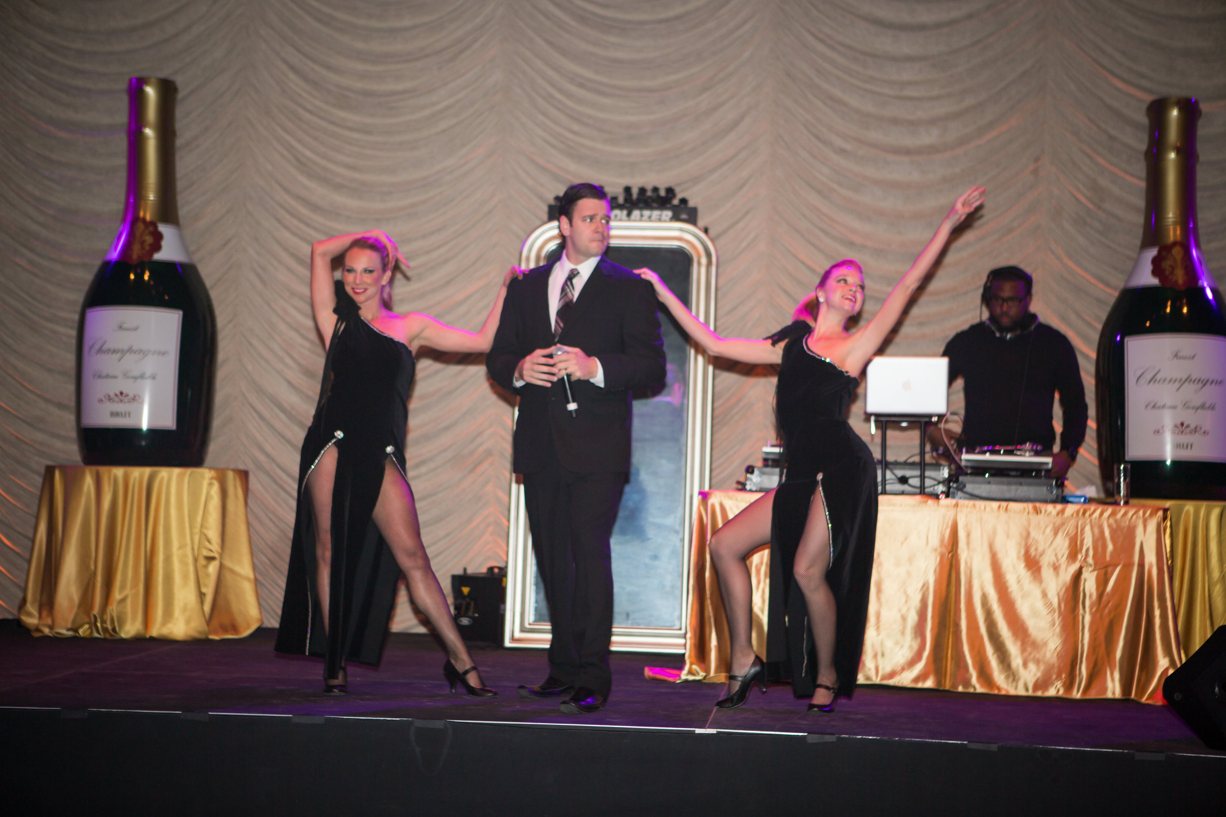 Two dancers performing in black dresses at a James Bond themed event