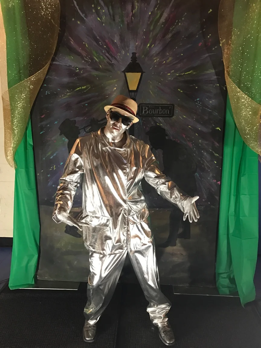 Gold Living Statue posing for a photo during a Mardi Gras Themed event