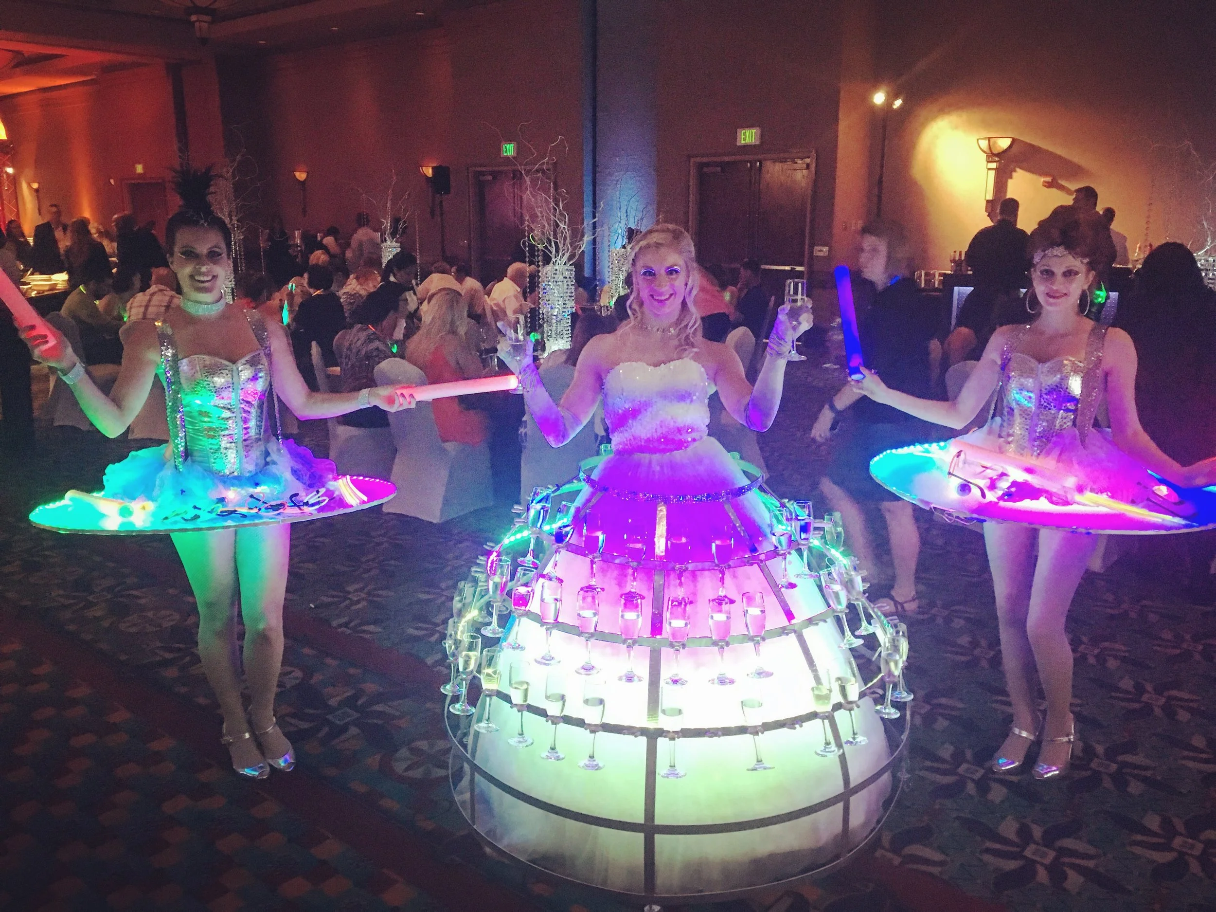 Two LED table performers and one champagne dress performer in an LED gown for a light up the night themed event