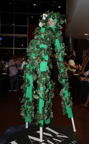 Four legged silt performer covered in green leaves for a jungle themed event