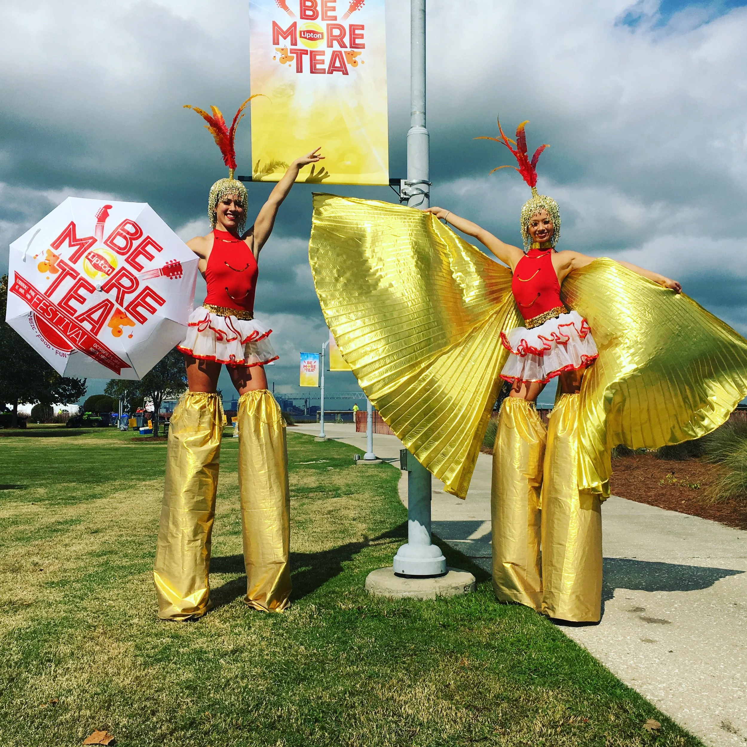 Colorful Winged Stilt Walkers at Outdoor Tea Event