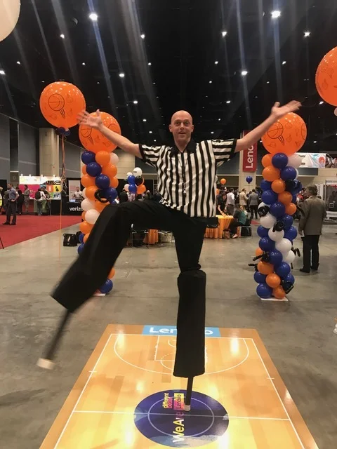 Referee-Inspired Stilt Walker at Basketball Event