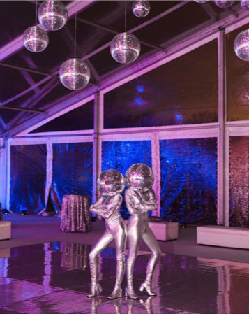 Duo Disco Ball Performers Posed Back-to-Back Under Ceiling of Disco Balls