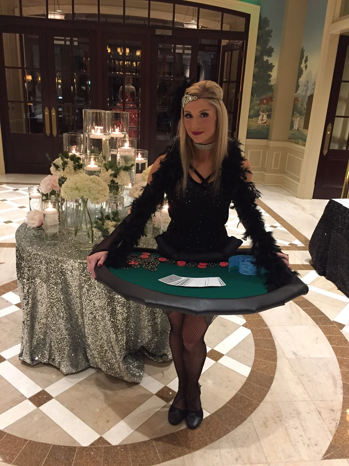 Blackjack Girl in a black costume with black feather boa carrying her blackjack table around her neck