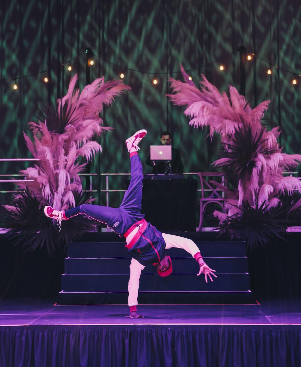 Breaker/B-boy performing on a stage balanced in a one-handed handstand