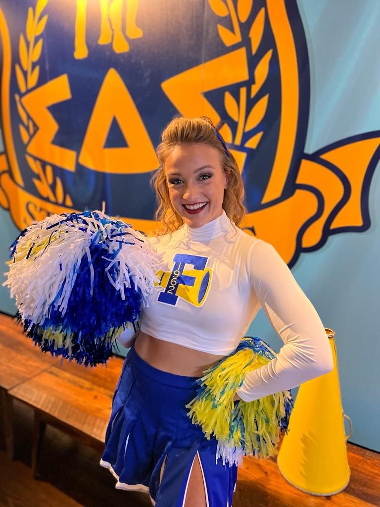 Retro Cheerleader in Blue, White, and Gold Uniform at Animal House Themed Event in Charleston, SC
