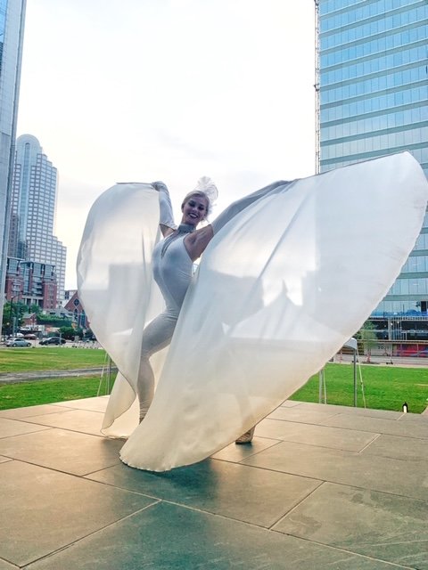 Ivory winged performer performing outside at an event