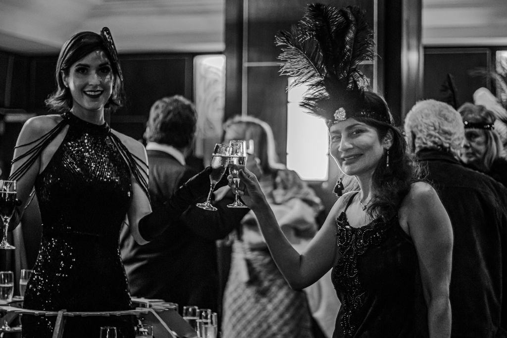 1920s champagne dress performer posing for a photo with a guest at a 20s themed event in Charleston, SC.